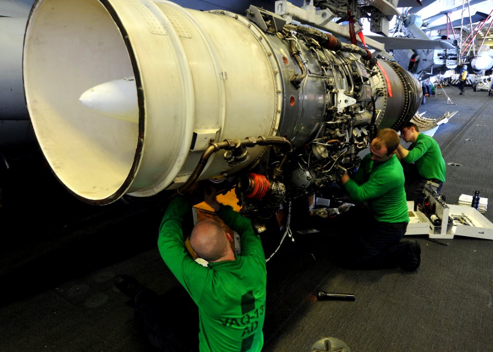 US Navy 110426-N-1004S-078 Sailors assigned to the Cougars of Tactical Electronic Warfare Squadron (VAQ) 139, install wiring to a new engine for an
