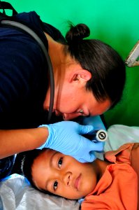 US Navy 110420-O-XX000-012 Aislinn Mangan, a registered nurse with Project Hope, tends to a patient during a Pacific Partnership 2011 medical commu