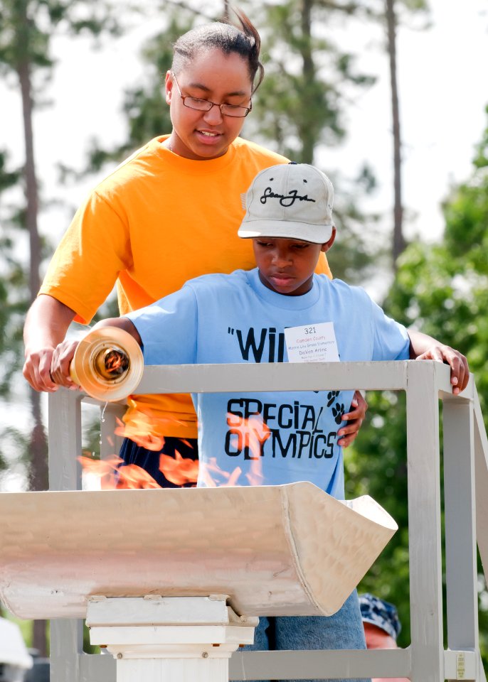 US Navy 110427-N-4010S-001 Religious Program Specialist Seaman Apprentice Jaleesa Overbey helps Da' Von Arline light the Special Olympics torch