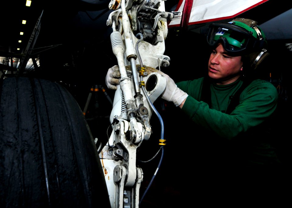 US Navy 110427-N-DM338-017 Aviation Structural Mechanic Airman Johnny strips grease from the landing gear of an F-A-18C Hornet aboard USS Ronald Re