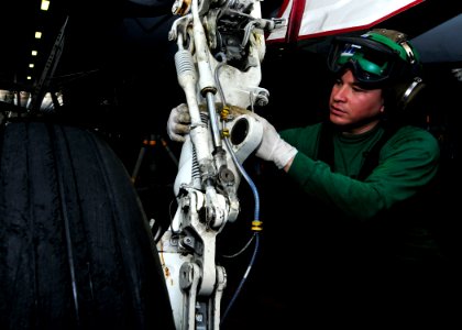 US Navy 110427-N-DM338-017 Aviation Structural Mechanic Airman Johnny strips grease from the landing gear of an F-A-18C Hornet aboard USS Ronald Re