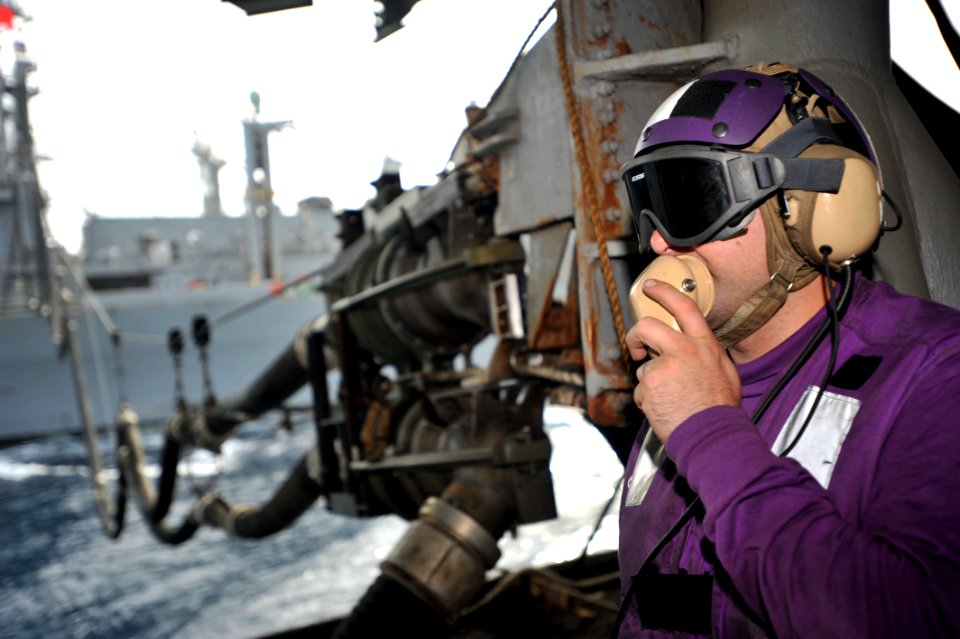 US Navy 110421-N-0569K-008 Aviation Boatswain's Mate (Fuels) Airman Michael A. Genera uses a sound-powered telephone to communicate with the fuels