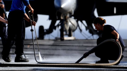 US Navy 110422-N-8040H-505 Aviation Boatswain's Mate (Handling) Airman Amanda Simnick and Sailors assigned to the air department scrub down the fl