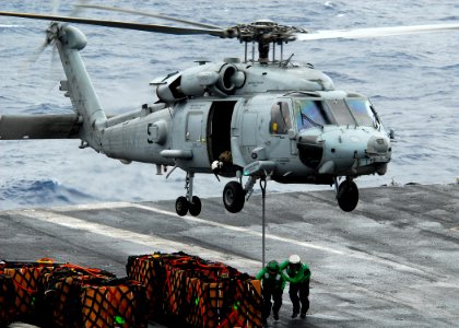 US Navy 110423-N-GL340-029 Logistics Specialist Seaman Immanuel Carter and Logistics Specialist 1st Class Kristopher Forest run to clear an SH-60H
