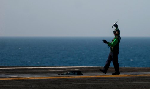 US Navy 110423-N-6505H-104 An aviation boatswain's mate (equipment) works on Catapult No. 4 on the flight deck of the Nimitz-class aircraft carrier