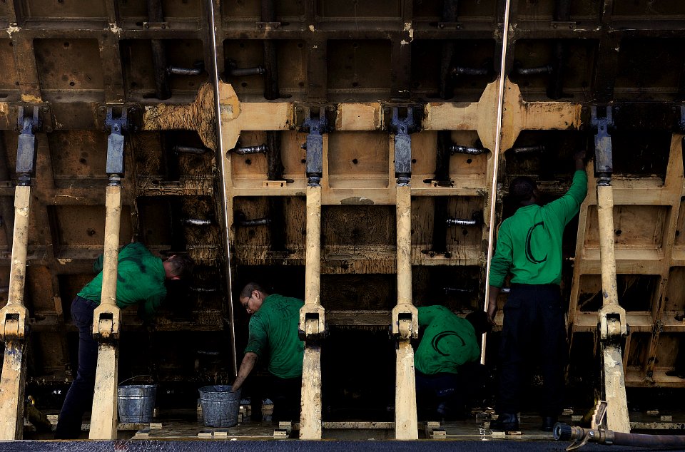 US Navy 110422-N-8040H-205 Sailors assigned to the air department degrease jet blast deflectors aboard the Nimitz-class aircraft carrier USS Carl V