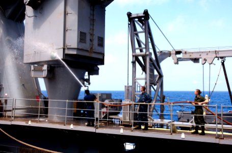 US Navy 110428-N-QP268-043 Seamen Richard Madrigal, left, Adam Spaulding and Olivia Barnett conduct a fresh water wash down on the 20-ton crane abo
