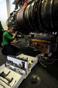 US Navy 110426-N-1004S-053 Aviation Machinist's Mate Airman Brandon Barlow installs essential wiring to the engine of an EA-6B Prowler