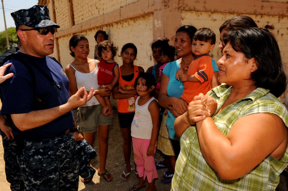 US Navy 110502-F-ET173-167 Hospital Corpsman 1st Class Carlos Aguilar, from Mexicali, Mexico, speaks with a group of Peruvians outside a temporary