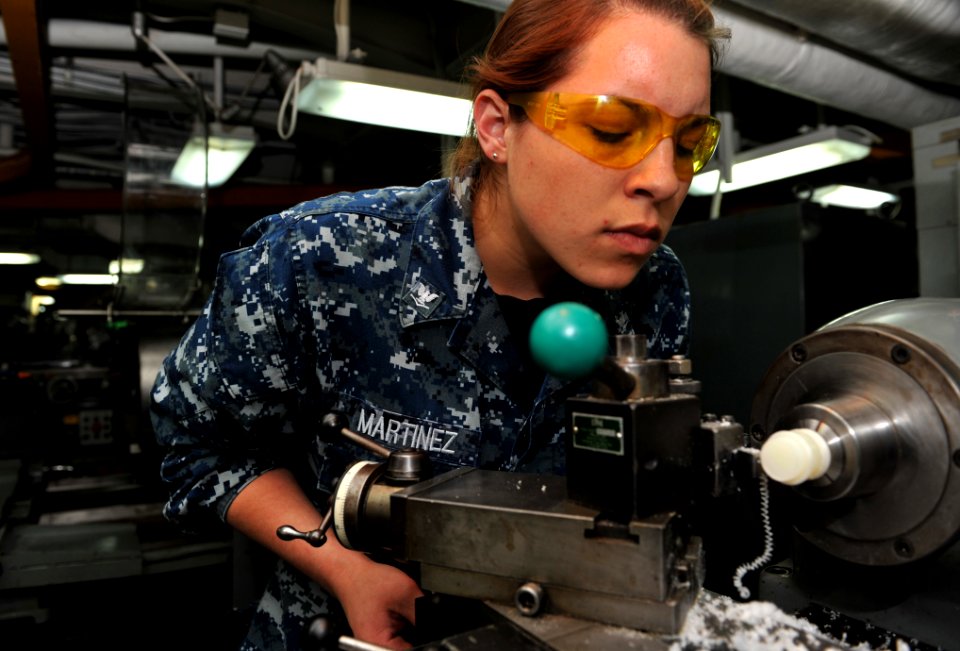 US Navy 110427-N-5031T-048 Machinery Repairman 3rd Class Chelsea Martinez fabricates a Teflon bushing in the sheet metal shop aboard USS John C. St