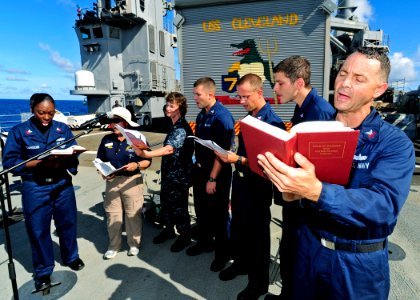 US Navy 110424-F-HS649-017 Choir members sing hymns during an Easter service on the flight deck of the amphibious transport dock ship USS Cleveland