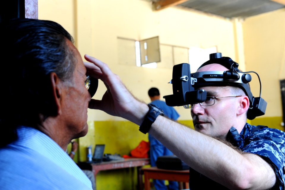 US Navy 110501-F-CF975-125 Capt. William Sray, an ophthalmologist, from Bridgeton, N.J., exams the eye of a patient at a medical clinic at Sagrado