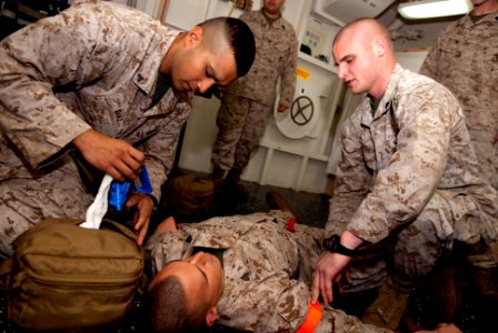 US Navy 110428-N-QP268-007 Cpl. Michael Diaz, right, reaches into a medical bag as Cpl. Joseph Diiorio, right, simulates applying a tourniquet to S