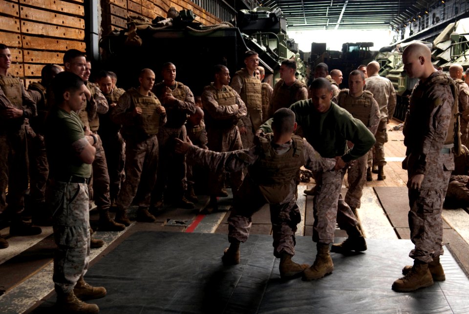 US Navy 110426-N-QP268-036 Cpl. Derek Black demonstrates a proper leg-sweeping movement to fellow Marines aboard USS Whidbey Island (LSD 41)