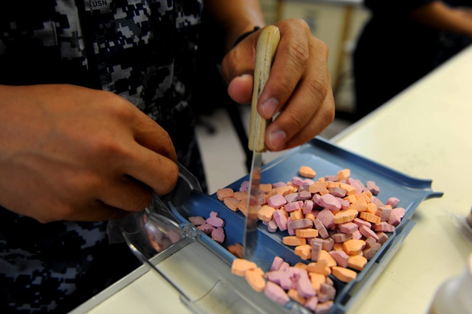 US Navy 110429-F-NJ219-021 Pharmacy technicians aboard the Military Sealift Command hospital ship USNS Comfort (T-AH 20) pre-package multivitamins