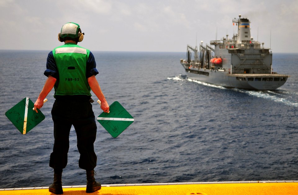 US Navy 110427-N-ZS026-059 Electronics Technician 3rd Class Robert Morris signals the Military Sealift Command fleet replenishment oiler USNS Joshu