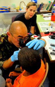 US Navy 110430-O-ZZ999-011 Royal New Zealand medical corps Lt. Cornel Darryl Tong and Lt. Cmdr. Magan Bayard examine a boy's eye at Northern Distri photo