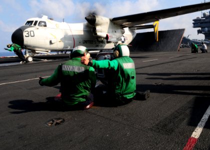 US Navy 110426-N-SG869-039 Sailors signal that a C-2A Greyhound assigned to the Providers of Fleet Logistics Combat Support Squadron (VRC) 30 is ho
