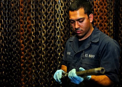 US Navy 110427-N-2908M-014 Seaman James Elmore lubricates a turnbuckle in preparation for an in-service inspection aboard USS Kearsarge (LHD 3)