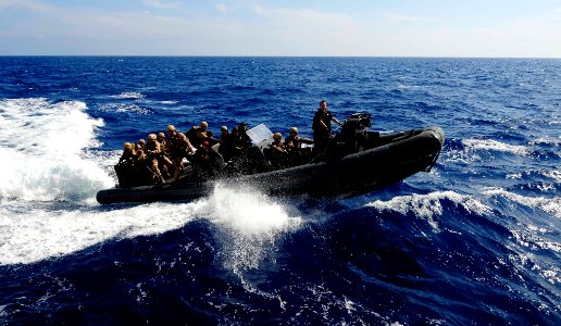US Navy 110505-N-OS574-442 Sailors and Marines ride in a rigid-hull inflatable boat during a visit, board, search and seizure, hook and pull exerci