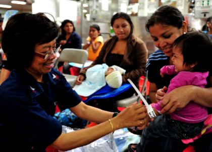 US Navy 110502-N-QD416-033 Hospital Corpsman 1st Class Florence Pacrem, from Zambales, Philippines, places a patient identification bracelet on a c
