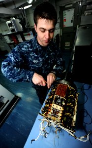 US Navy 110430-N-OY799-077 Aviation Electrician's Mate Airman Robert Jones, from Cape Girardeau, Mo., conducts maintenance on an F-18 generator