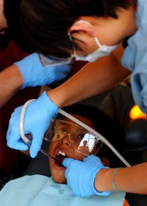 US Navy 110503-N-NY820-297 Hospital Corpsman 3rd Class Dawn Kraklio performs dental work on a young patient during a Continuing Promise 2011 commun photo