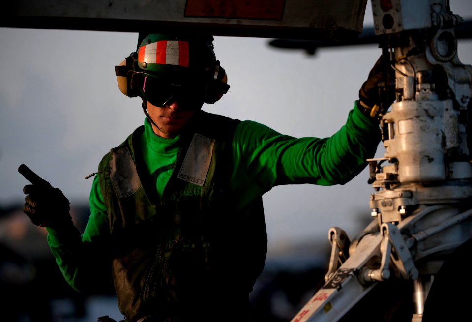 US Navy 110430-N-DR144-838 viation Boatswain's Mate (Equipment) 3rd Class Joshua White positions an F-A-18C Hornet on a catapult shuttle for launch