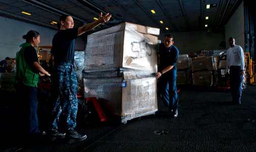 US Navy 110504-N-DR144-226 ulinary Specialist 1st Class Linda Colter, assigned to the supply department, directs the movement of stores in the hang