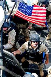 US Navy 110504-N-RC734-123 Boatswain's Mate 3rd Class Justin Sims looks up from a rigid-hull inflatable boat prior to boarding USS Comstock (LSD 45