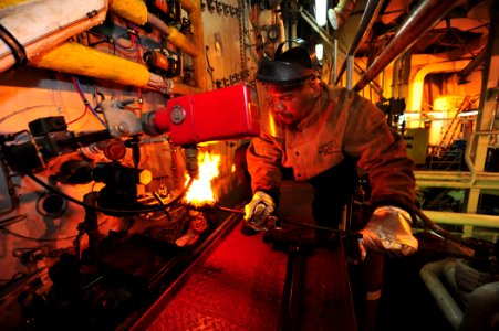 US Navy 110504-F-ET173-055 Engine Utility Willie Grant lights off a burner aboard the Military Sealift Command hospital ship USNS Comfort (T-AH 20)