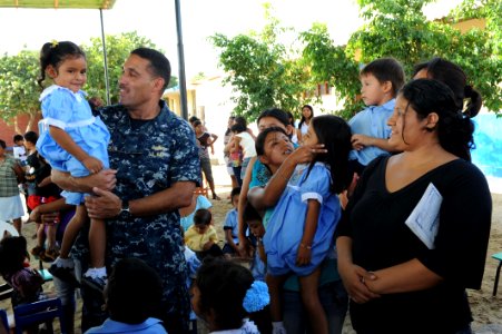 US Navy 110508-F-ET173-696 Commodore Brian Nickerson chats with a Peruvian girl following a ribbon cutting ceremony at the Cruz Maria Minan Quezada