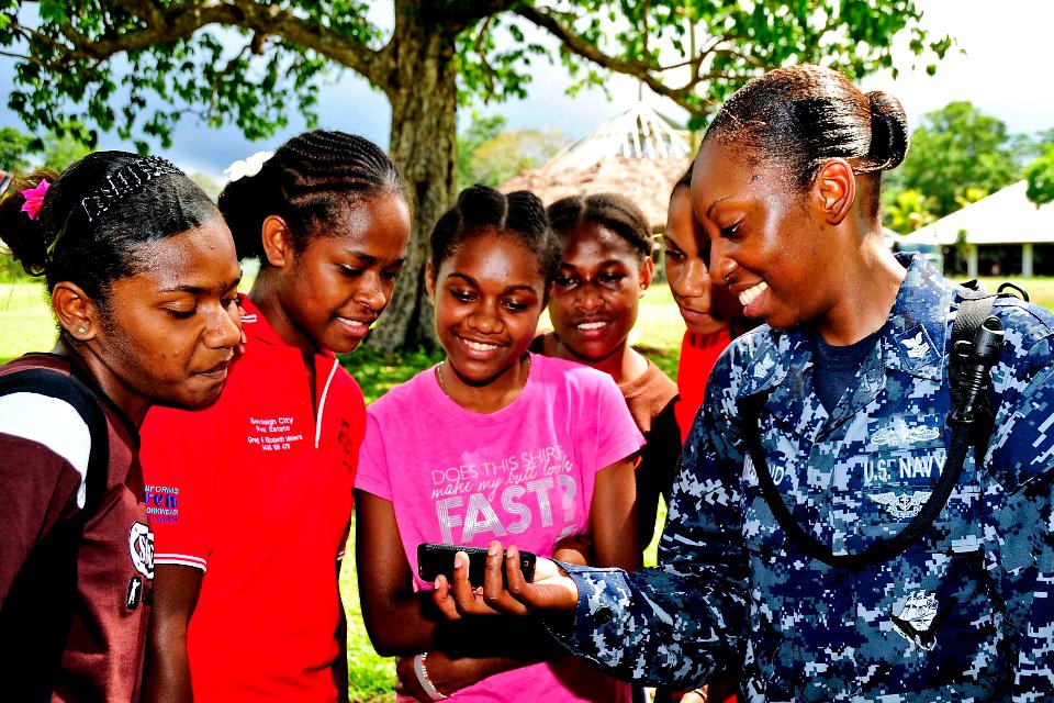 US Navy 110502-F-HS649-178 Hospital Corpsman 1st Class Cassandra Townsend shows students a music video on her cell phone at Matevulu College during