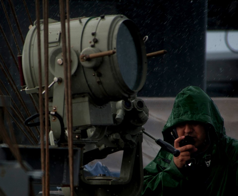 US Navy 110509-N-DR144-578 Operations Specialist 3rd Class David Ayala talks with other watch standers on a sound-powered telephone while standing