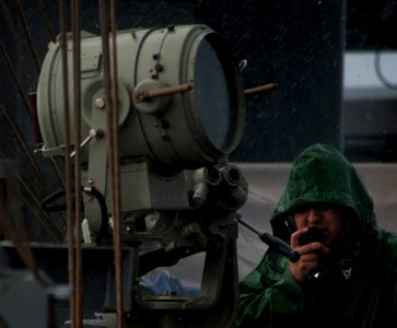 US Navy 110509-N-DR144-578 Operations Specialist 3rd Class David Ayala talks with other watch standers on a sound-powered telephone while standing