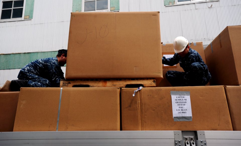 US Navy 110510-N-6720T-014 Sailors aboard the aircraft carrier USS George Washington (CVN 73) place boxes of blankets donated by George Washington