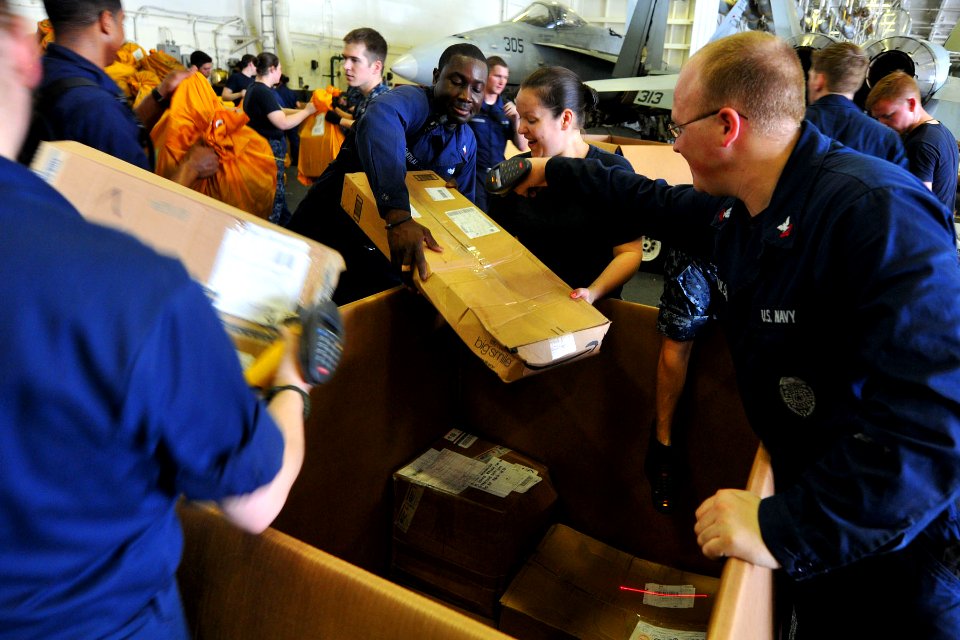 US Navy 110506-N-1004S-192 Personal Specialist Seaman Keith Joseph, from Oakland, Calif., holds a parcel as Master-at-Arms 2nd Class Michael Paulse