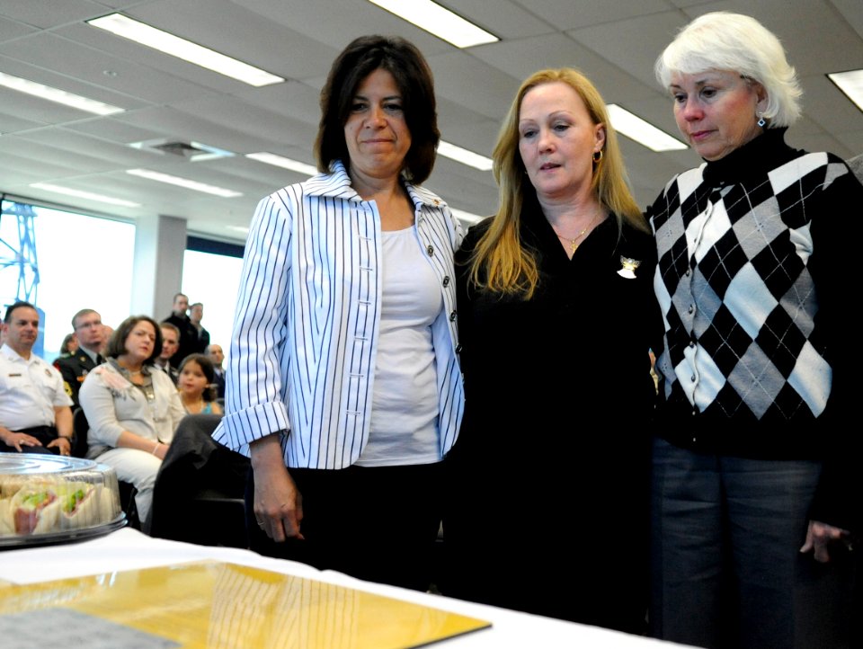 US Navy 110506-N-KK330-237 Cindy Dietz, Maureen Murphy and Donna Axelson look at a copy of the brass plaque with the initials of their sons and oth