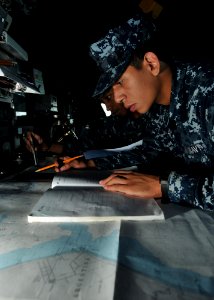 US Navy 110509-N-NL541-126 Sailors perform nautical chart corrections aboard Thach