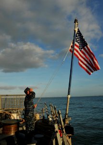 US Navy 110509-N-NL541-028 Seaman Jeremy Inmaniannuzzo raises the national ensign during morning colors aboard USS Thach (FFG 43)