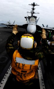 US Navy 110509-N-OY799-167 Aviation Boatswain's Mate (Handling) 3rd Class Mike Nicholas directs an F-A-18E Super Hornet aboard USS John C. Stennis