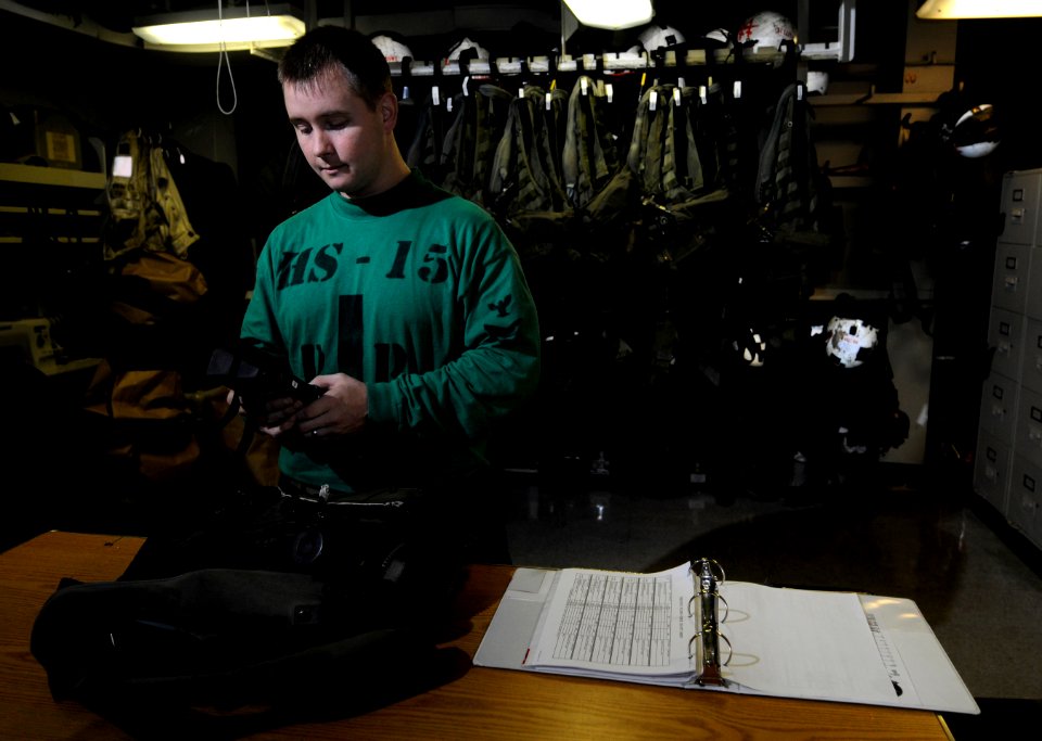 US Navy 110509-N-GZ277-049 Aircrew Survival Equipmentman 1st Class Chad McMurray inspects a PRQ-7 radio in the paraloft shop aboard USS Carl Vinson