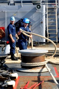 US Navy 110512-N-7293M-144 Seaman Andrew Mitchell flips a mooring line off the starboard capstan of the amphibious transport dock ship USS Ponce (L photo