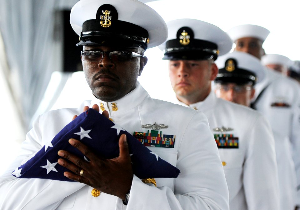 US Navy 110510-N-WP746-257 Master Chief Master-at-Arms Melvin Lewis, assigned to U.S. Pacific Fleet, performs a flag passing ceremony
