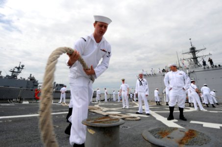 US Navy 110511-N-TB177-314 Fire Controlman 3rd Class John Barton pulls in a line aboard the guided-missile destroyer USS Truxtun (DDG 103) as the s