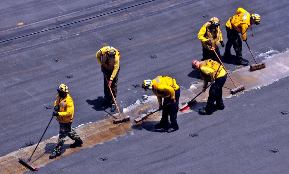 US Navy 110510-N-0074G-001 Sailors assigned to the aircraft carrier USS Enterprise (CVN 65) scrub the guidelines on the flight deck to make them mo