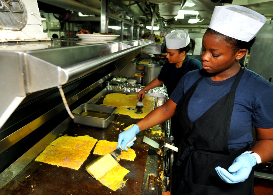US Navy 110508-N-1004S-090 Culinary Specialist 3rd Class Maisha Dublin and Culinary Specialist Seaman Christina Clayton cook omelets as part of a S