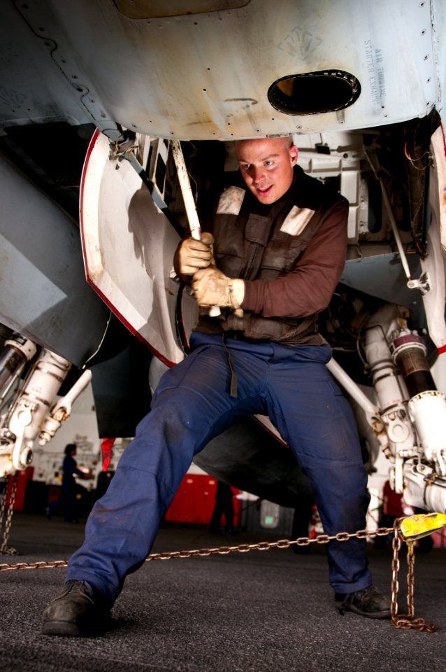 US Navy 110510-N-BT887-003 Aviation Electronics Technician Airman Zac Winking pumps the auxiliary hangar unit of an F-A-18C Hornet aboard USS John