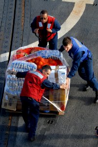 US Navy 110510-N-ZI300-073 Sailors aboard USS Boone (FFG 28) move a pallet of supplies in preparation of a vertical replenishment with USS Thach (F