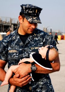 US Navy 110510-N-DU438-056 Ensign Kenneth J. Perfido, assigned to the guided-missile cruiser USS Gettysburg (CG 64), holds his daughter on the pier